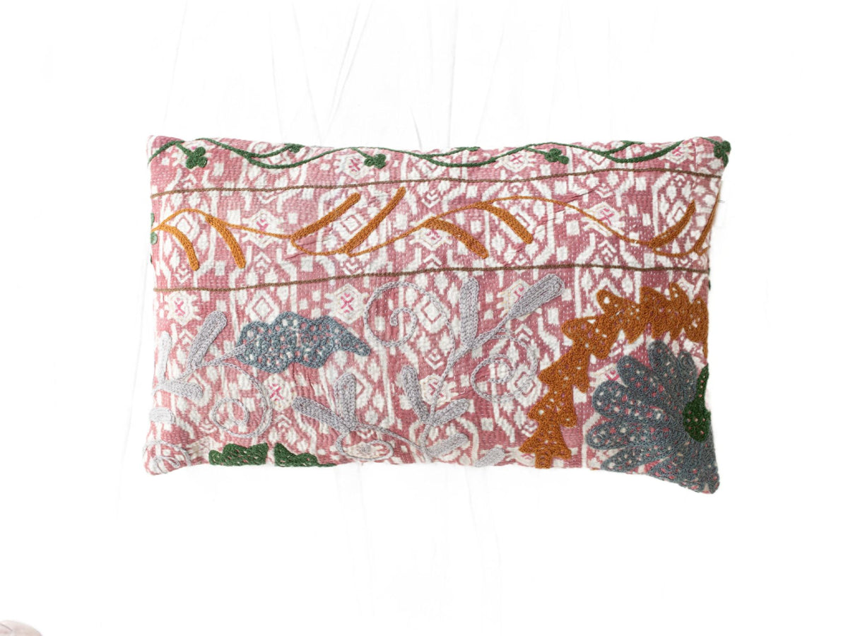 Suzani Kissenbezug 30x50 cm in zartem Rosa mit weißem Ornamentmuster und gestickten orientalischen Motiven in Grünocker und Grau im Boho-Vintage-Stil.