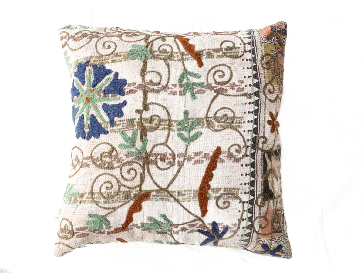 Suzani Kissenbezug 50x50 cm mit farbenfroher Boho-Ethno-Blumenstickerei in Blau, Grün und Braun auf weißem Hintergrund mit Vintage-Wickelmuster und Bordüre.